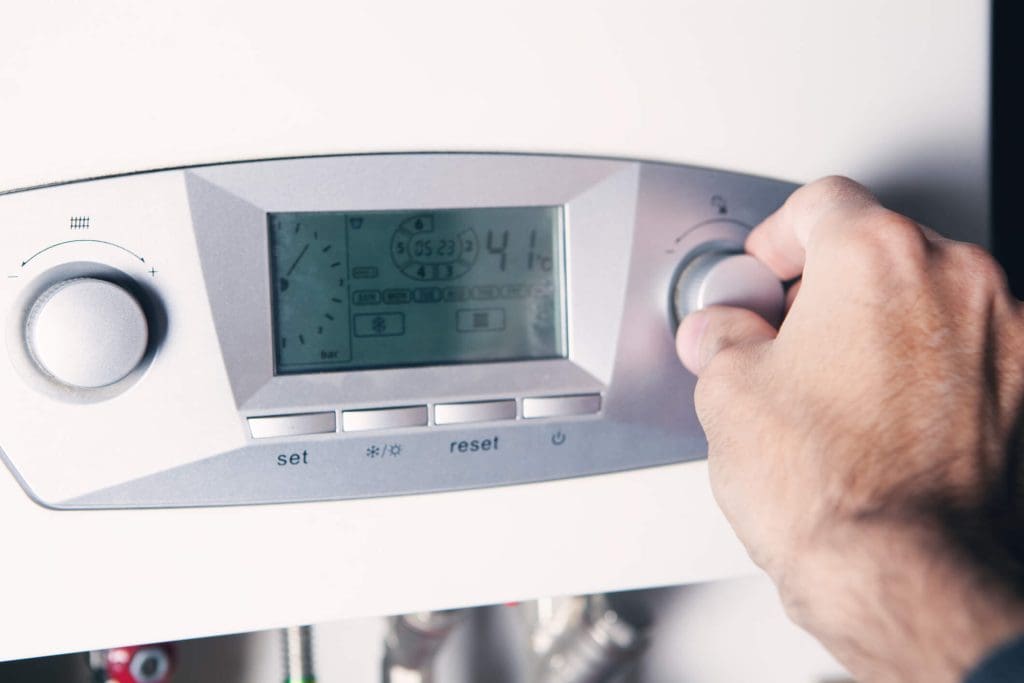 dreamstime_m_219887601 Worker set up central gas heating boiler at home